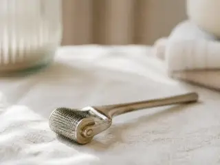 Rouleau métallique à picots posé sur un linge clair, picots flous, sans marque visible, lumière douce